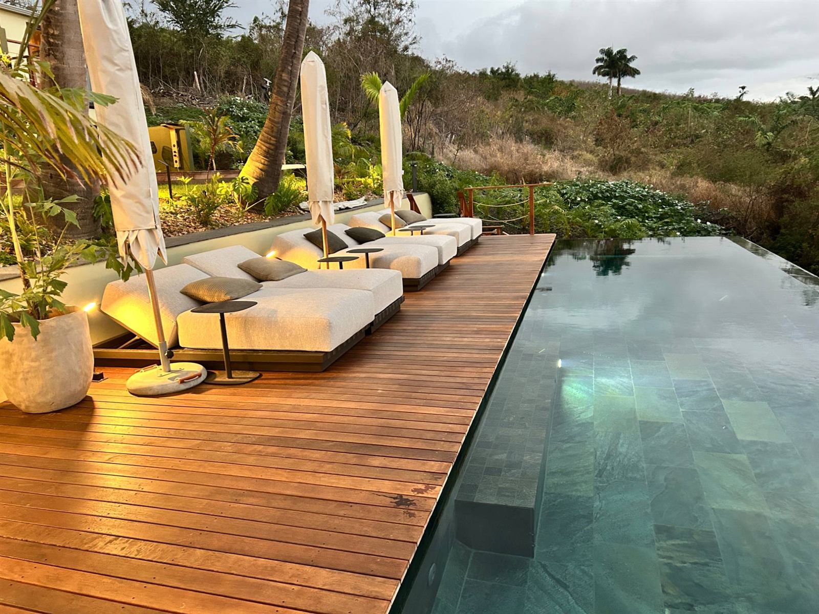 Transats sur la terrasse bois le long de la piscine