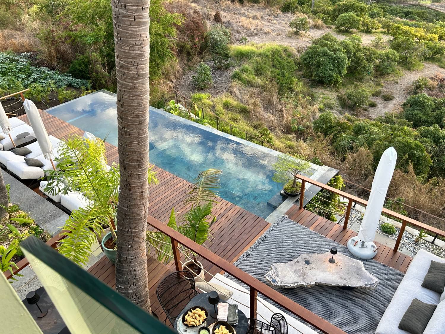 Vue plongeante sur la piscine à débordement et les terrasses bois