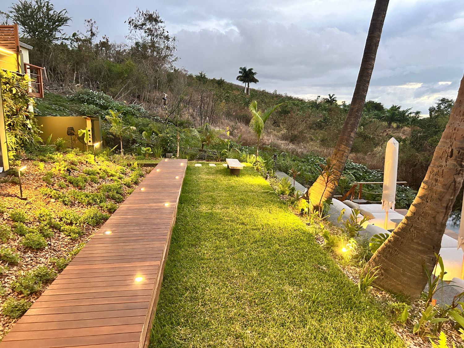 Cheminement en bois avec spots encastrés dans le jardin